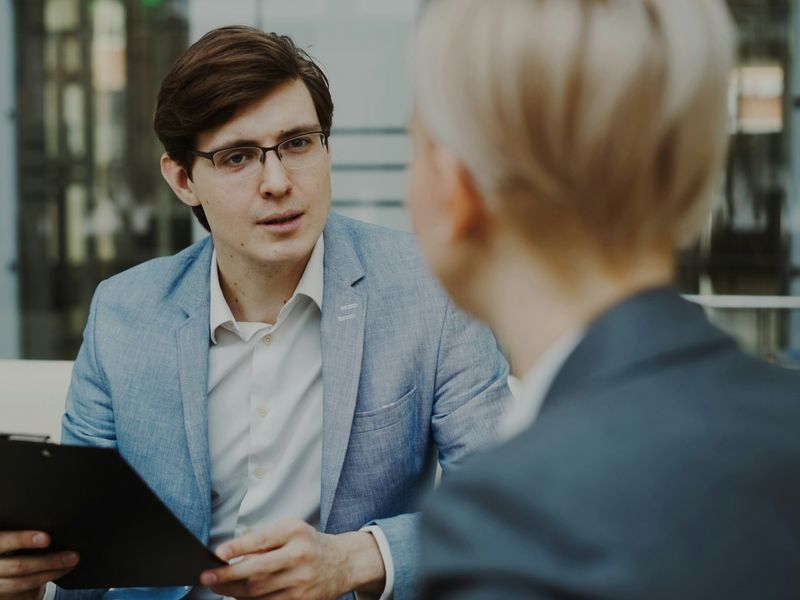 A researcher with a clipboard conducting an interview