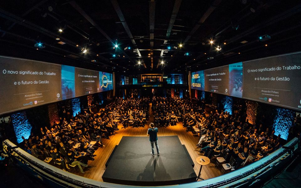 A speaker on stage addressing a large conference audience